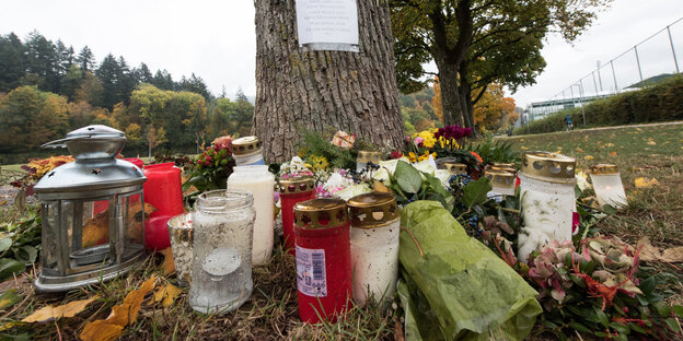 Kerzen und Blumen stehen vor einem Baum Kerzen und Blumen stehen vor einem Baum