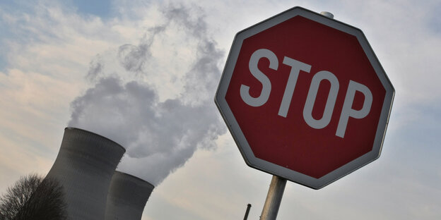 Ein Stoppschild. Im Hintergrund zwei Kühltürme Ein Stoppschild. Im Hintergrund zwei Kühltürme