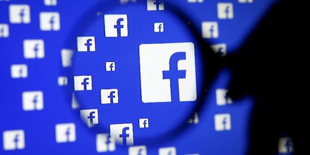 Eine Lupe vergrößert das blau-weiße Facebook-Logo. Eine Lupe vergrößert das blau-weiße Facebook-Logo.