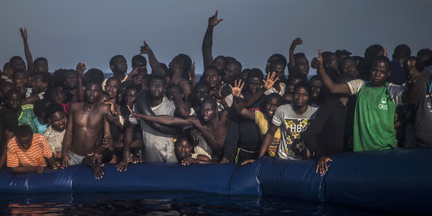 Viele Menschen stehen auf einem Schlachboot vor der libyschen Küste Viele Menschen stehen auf einem Schlachboot vor der libyschen Küste