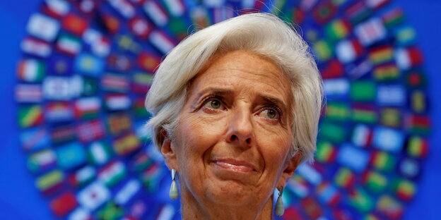 eine Frau vor einem Kranz, der aus den Flaggen der IWF-Staaten besteht eine Frau vor einem Kranz, der aus den Flaggen der IWF-Staaten besteht