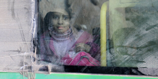 Ein Mädchen guckt aus einem Bus, mit dem sie aus Ost-Aleppo fliehen kann