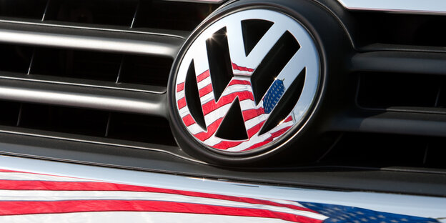 Im Volkswagen-Emblem eines Autos spiegelt sich die US-amerikanische Flagge Im Volkswagen-Emblem eines Autos spiegelt sich die US-amerikanische Flagge