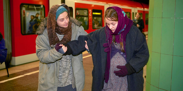 Zwei Frauen in der Münchner S-Bahn. Die eine ist schwanger und hält sich den Bauch. Die andere stützt sie. Zwei Frauen in der Münchner S-Bahn. Die eine ist schwanger und hält sich den Bauch. Die andere stützt sie.