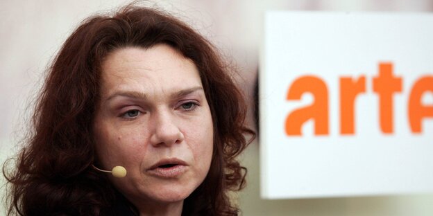 Aslı Erdoğan mit einem Kopfmikrofon, daneben das Logo von „Arte“ Aslı Erdoğan mit einem Kopfmikrofon, daneben das Logo von „Arte“