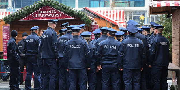 Eine Gruppe Polizisten vor einer Weihnachtsmarktbude Eine Gruppe Polizisten vor einer Weihnachtsmarktbude
