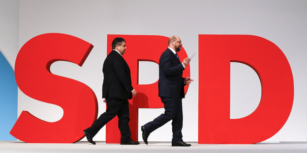Vor einem großen roten SPD-Logo laufen Sigmar Gabriel und Martin Schulz entlang Vor einem großen roten SPD-Logo laufen Sigmar Gabriel und Martin Schulz entlang