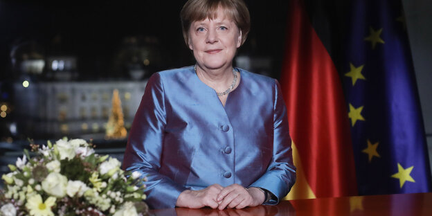 Angela Merkel im blauen Blazer vor Fahnen Deutschlands und der Europäischen Union Angela Merkel im blauen Blazer vor Fahnen Deutschlands und der Europäischen Union