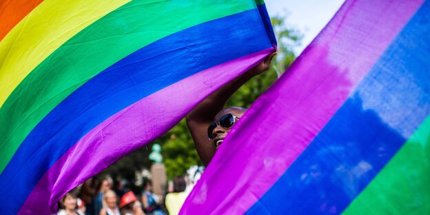 Eine Person schwenkt Regenbogenfahnen auf einer LGBT-Demo in Kopenhagen im Jahr 2013 Eine Person schwenkt Regenbogenfahnen auf einer LGBT-Demo in Kopenhagen im Jahr 2013