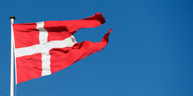 eine dänische Flagge vor blauem Himmel eine dänische Flagge vor blauem Himmel