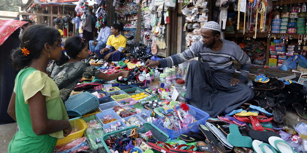 Ein Mann in einem kleinen Laden in Myanmar verkauft zwei Mädchen etwas
