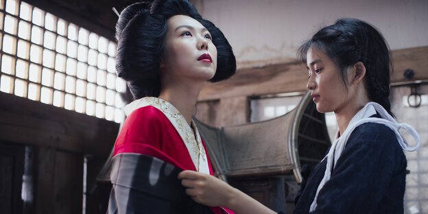 Zwei koreanische Frauen, eine elegant, die andere schlicht gekleidet Zwei koreanische Frauen, eine elegant, die andere schlicht gekleidet