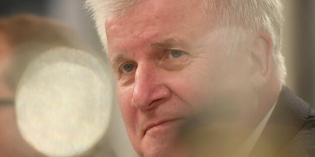 Horst Seehofer hinter verschwommenen Pflanzen und Lichtreflexen Horst Seehofer hinter verschwommenen Pflanzen und Lichtreflexen