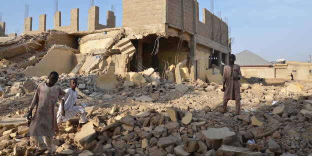 Auf der Ruine einer Grundschule in Zaria stehen Kinder und blicken in die Kamera. Auf der Ruine einer Grundschule in Zaria stehen Kinder und blicken in die Kamera.