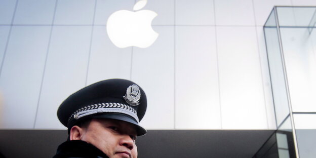 Ein chinesischer Polizist steht vor einem App-Store in Peking Ein chinesischer Polizist steht vor einem App-Store in Peking