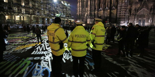 Polizisten in gelben Schutzwesten stehen in der Silvesternacht in Köln vor dem Dom Polizisten in gelben Schutzwesten stehen in der Silvesternacht in Köln vor dem Dom
