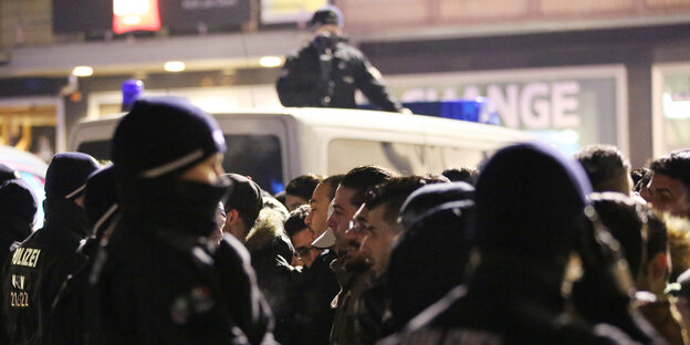 Polizeibeamte und männliche Besucher stehen sich in der Silvesternacht in Köln gegenüber Polizeibeamte und männliche Besucher stehen sich in der Silvesternacht in Köln gegenüber