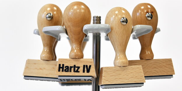 vier Stempel, auf einem steht „Hartz IV“ vier Stempel, auf einem steht „Hartz IV“