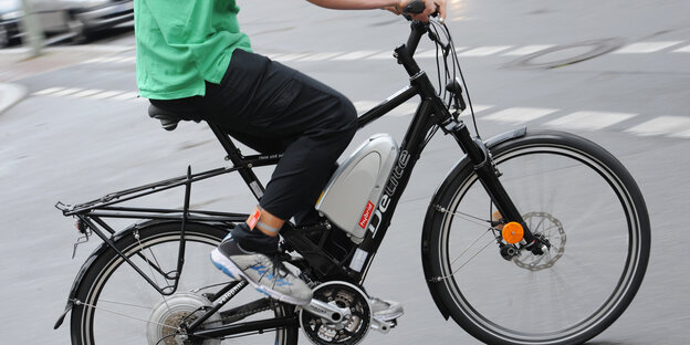 Ein Fahrradfahrer fährt auf einem Pedelec Ein Fahrradfahrer fährt auf einem Pedelec