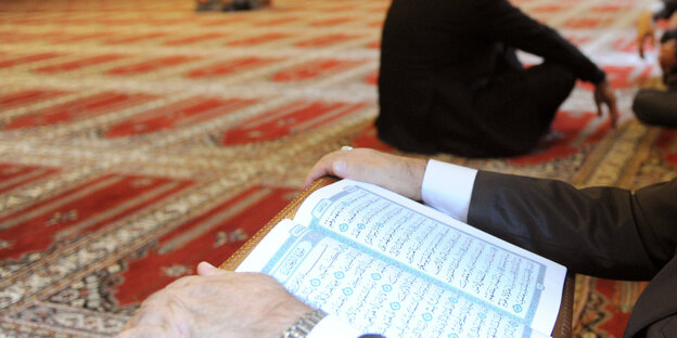 Männer sitzen in einer Moschee Männer sitzen in einer Moschee