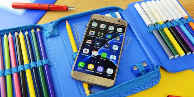 Ein Smartphone in einer bunten Federtasche Ein Smartphone in einer bunten Federtasche