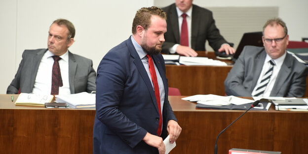 Ein Mann im Anzug geht durch das Parlament, er schaut verunsichert Ein Mann im Anzug geht durch das Parlament, er schaut verunsichert