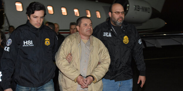 El Chapo in beiger Jacke wird von zwei Agenten abgeführt El Chapo in beiger Jacke wird von zwei Agenten abgeführt