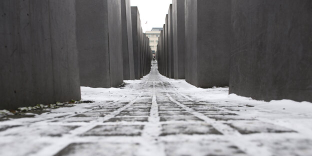 Zwischen den Stelen des Holocaust-Mahnmals in Berlin liegt Schnee Zwischen den Stelen des Holocaust-Mahnmals in Berlin liegt Schnee