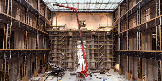 Ein Kran steht mitten in der Halle des Humboldt Forums, das gerade gebaut wird