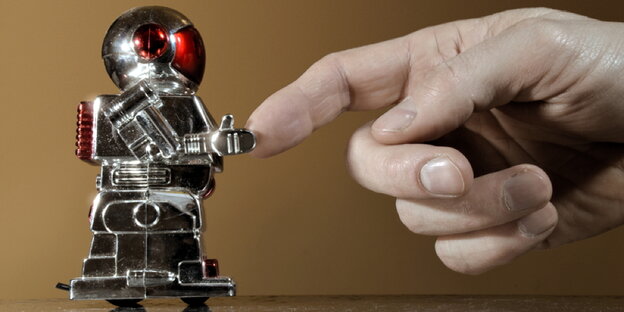 Ein Roboter berührt den Finger einer ausgestreckten menschlichen Hand Ein Roboter berührt den Finger einer ausgestreckten menschlichen Hand