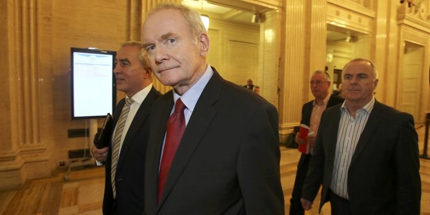 Im Vordergrund Martin McGuinness in einem Pulk von Männern Im Vordergrund Martin McGuinness in einem Pulk von Männern