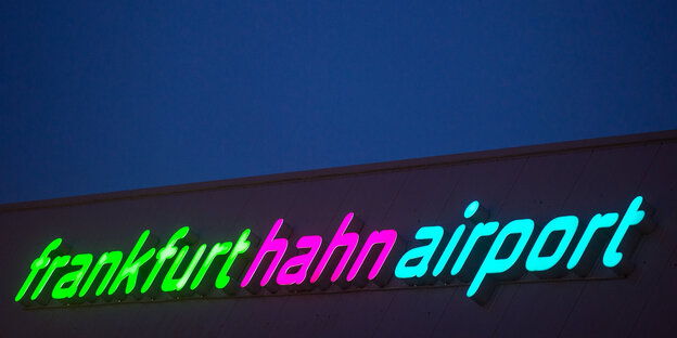 Bunt beleuchteter Schriftzug des Flughafen im Dunkeln Bunt beleuchteter Schriftzug des Flughafen im Dunkeln
