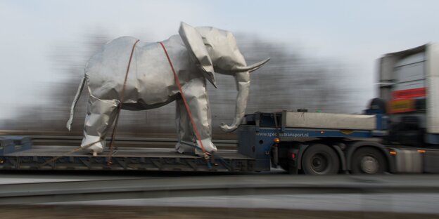 Eine Elefantenskulput aus Metall wird auf einem Laster transportiert Eine Elefantenskulput aus Metall wird auf einem Laster transportiert
