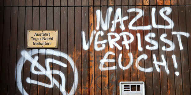 An ein braunes Garagentor ist die Zeile „Nazis verpisst euch!" geschrieben An ein braunes Garagentor ist die Zeile „Nazis verpisst euch!" geschrieben