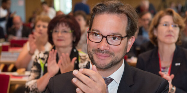 Ein Mann mit Brille klatscht in die Hände Ein Mann mit Brille klatscht in die Hände