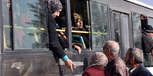 Syrier verassen mit den Bus die umkämpften Gebiete