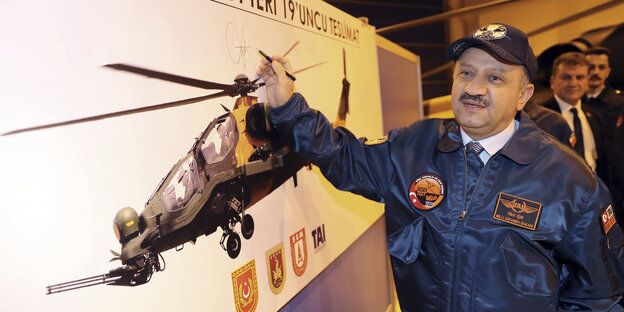 Der türkische Verteidigungsminister Firki Isik vor einem Plakat mit einem Helikopter Der türkische Verteidigungsminister Firki Isik vor einem Plakat mit einem Helikopter