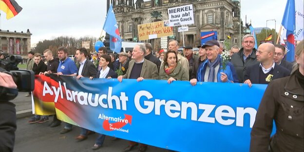 AfD-Anhänger mit einem Schriftbanner, auf dem „Asyl braucht Grenzen“ steht AfD-Anhänger mit einem Schriftbanner, auf dem „Asyl braucht Grenzen“ steht