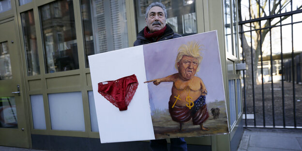 Ein mann hält ein Kunstwerk auf dem ein nackter Donald Trump auf eine Unterhose zeigt Ein mann hält ein Kunstwerk auf dem ein nackter Donald Trump auf eine Unterhose zeigt