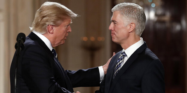 Donald Trump schüttelt dem Richter Neil Gorsuch die Hand und fasst ihn an die Schulter