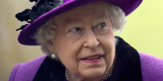 Die Queen in violettem Hut und passendem Kostüm Die Queen in violettem Hut und passendem Kostüm