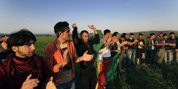 Männer stehen auf einem Feld und klatschen in die Hände Männer stehen auf einem Feld und klatschen in die Hände