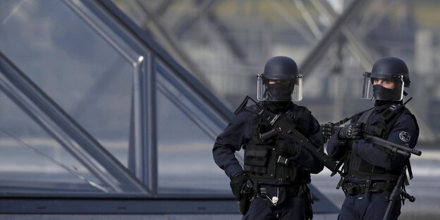 Zwei schwer bewaffnete Polizisten bewachen das Areal vor dem Eingang zum Louvre Zwei schwer bewaffnete Polizisten bewachen das Areal vor dem Eingang zum Louvre