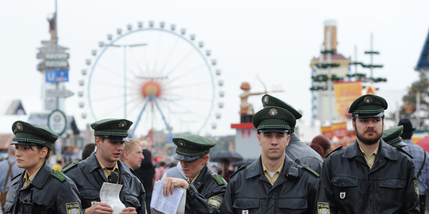 Polizistinnen und Polizisten nebeneinander, dahinter Oktoberfest Polizistinnen und Polizisten nebeneinander, dahinter Oktoberfest