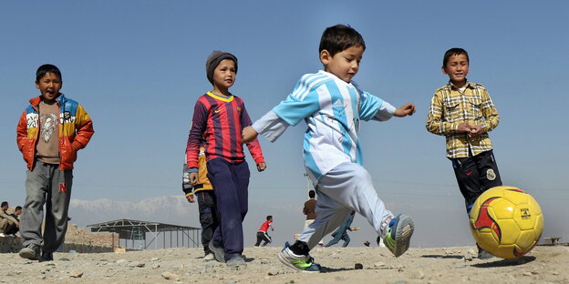 Vier Kinder spielen Fußball Vier Kinder spielen Fußball