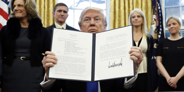 Donald Trump hält eine Mappe mit Papieren Richtung Kamera Donald Trump hält eine Mappe mit Papieren Richtung Kamera