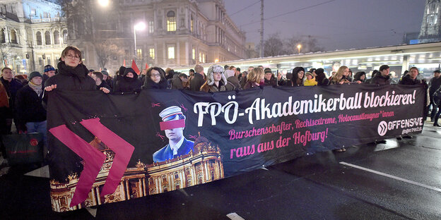 Mehrere Personen schreiten, ein Transparent haltend, einer Demonstration voran. Es ist Abend. Mehrere Personen schreiten, ein Transparent haltend, einer Demonstration voran. Es ist Abend.
