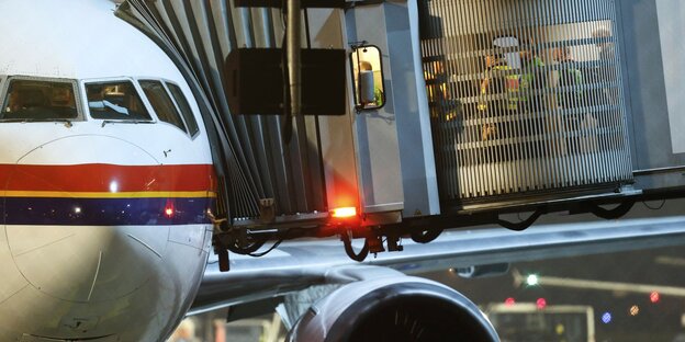 Ein Flugzeug auf einem abendlichen Flughafen - mit Gangway, durch die Polizisten gehen. Ein Flugzeug auf einem abendlichen Flughafen - mit Gangway, durch die Polizisten gehen.