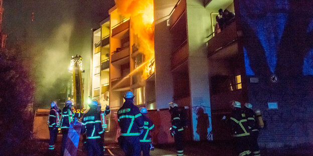 Feuerwehr im Einsatz vor einem brennenden Haus Feuerwehr im Einsatz vor einem brennenden Haus