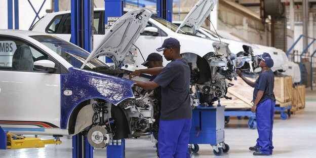 Arbeiter stehen an Autokarrossen Arbeiter stehen an Autokarrossen
